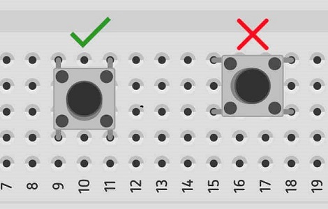 Una foto de un push button de 4 pines, mostrando la forma correcta de conexión en el protoboard cruzando el canal central.